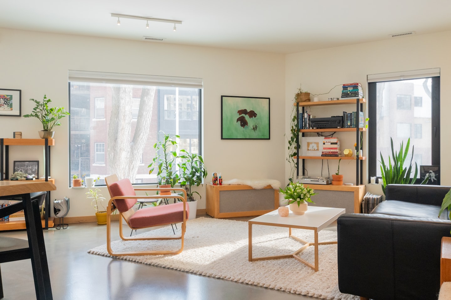 Moderne woonkamer met rode fauteuil en planten.
